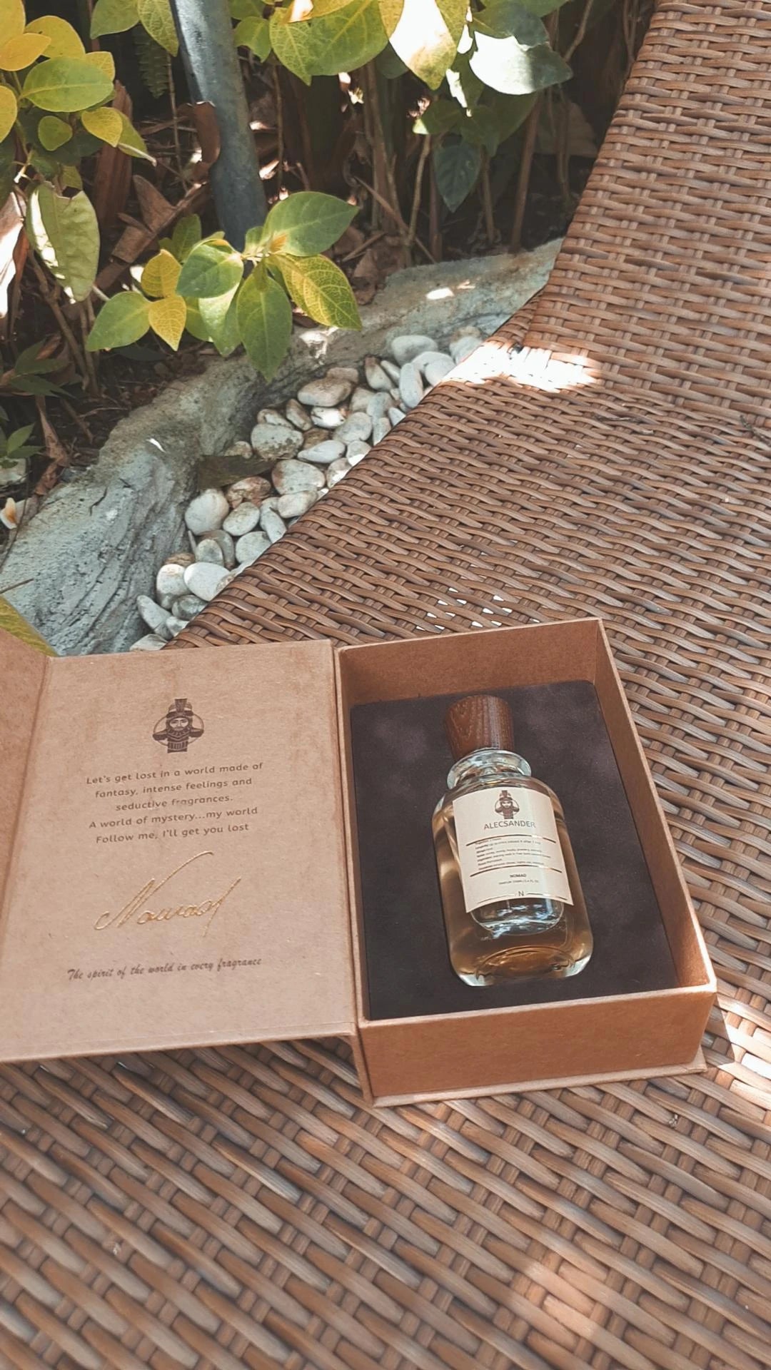 Image on the About Us page showcasing the Nomad Alecsander perfume bottle gracefully presented in its box on a sunbed, evoking a luxurious and tranquil ambiance